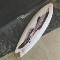 White surfboard with abstract design on a black surface