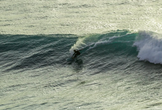 Matthew doing a grab rail cutback on a big wave whilst riding a diamond tail single fin.